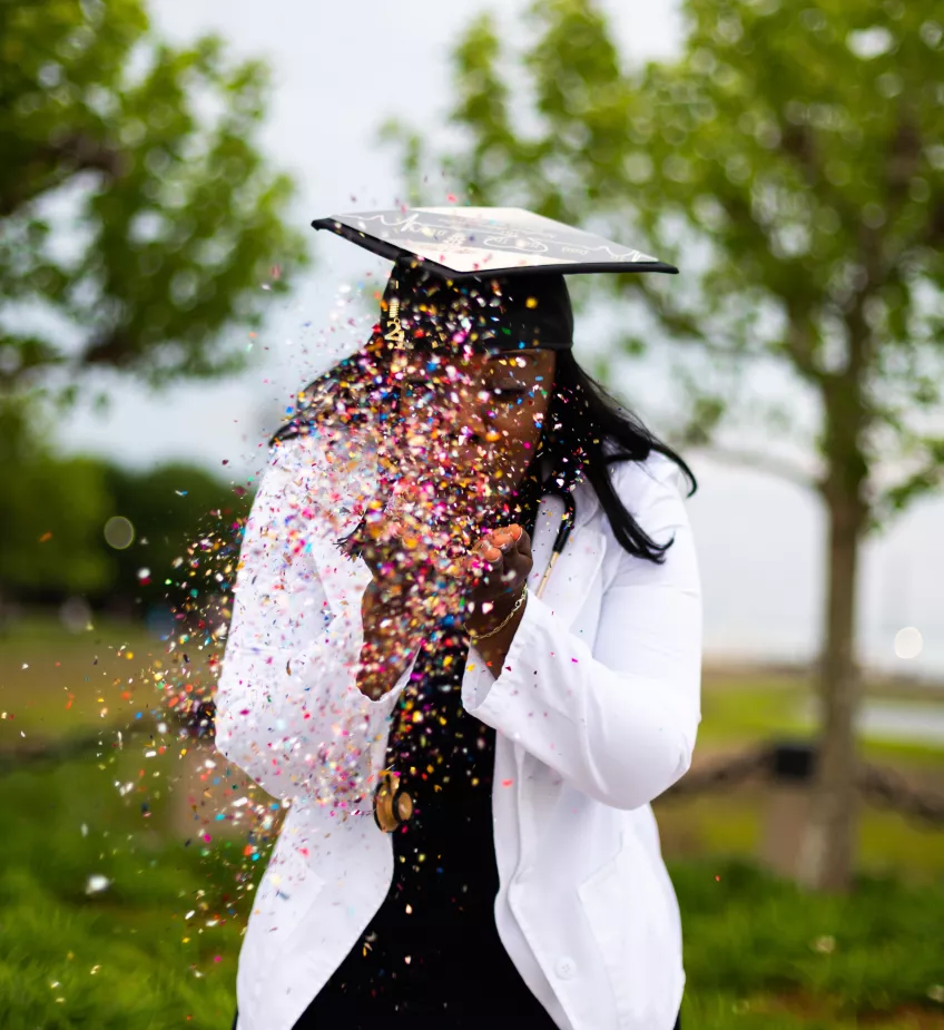 Nyutexaminerad student blåser konfetti. Foto.